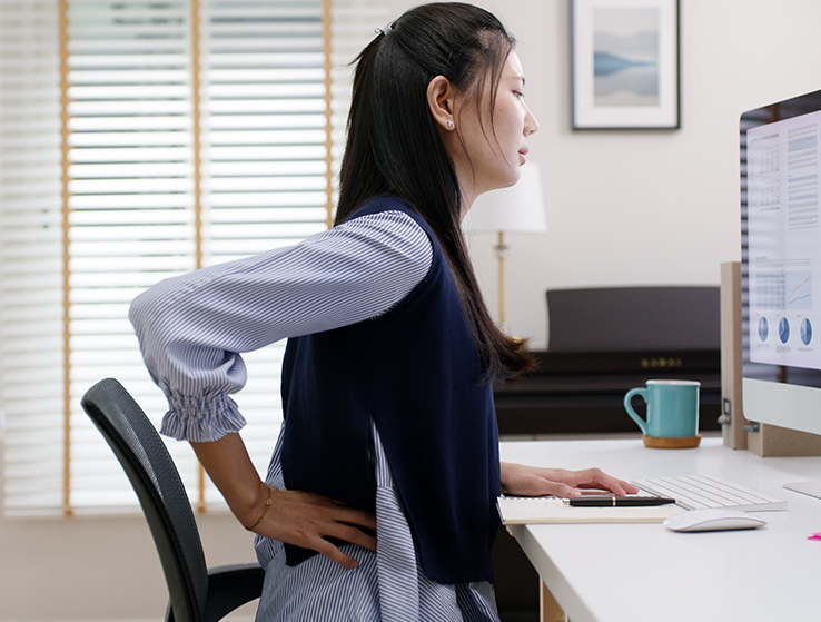Woman experiencing hip pain while at work