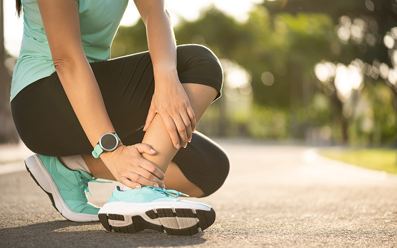 A woman suffering an ankle injury while running