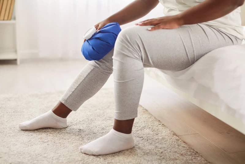 Person icing knee following injury.