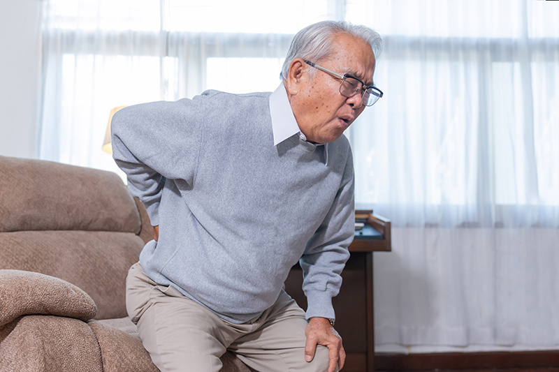 An elderly man suffering from lower back pain