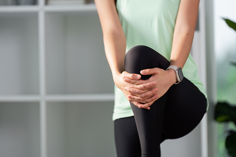 Woman applying gentle pressure to her knee while stretching